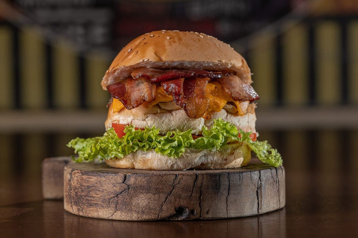 Hambúrguer com bacon e queijo derretido, foto real da casa